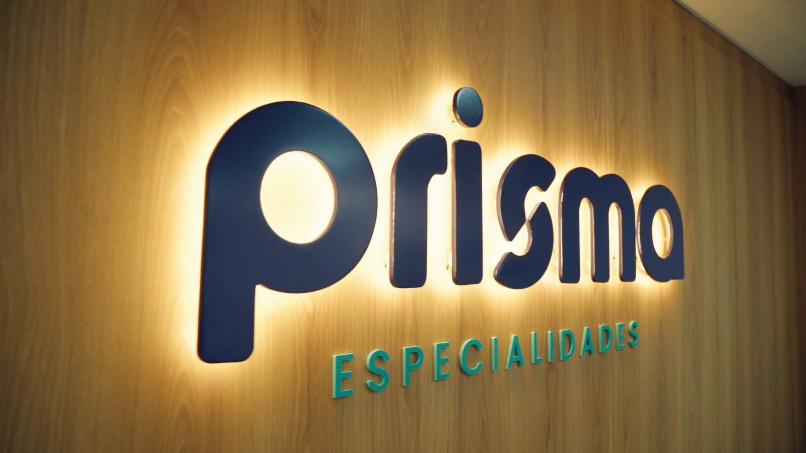 Logo da Prisma Especialidades na parede da recepção, em Novo Hamburgo